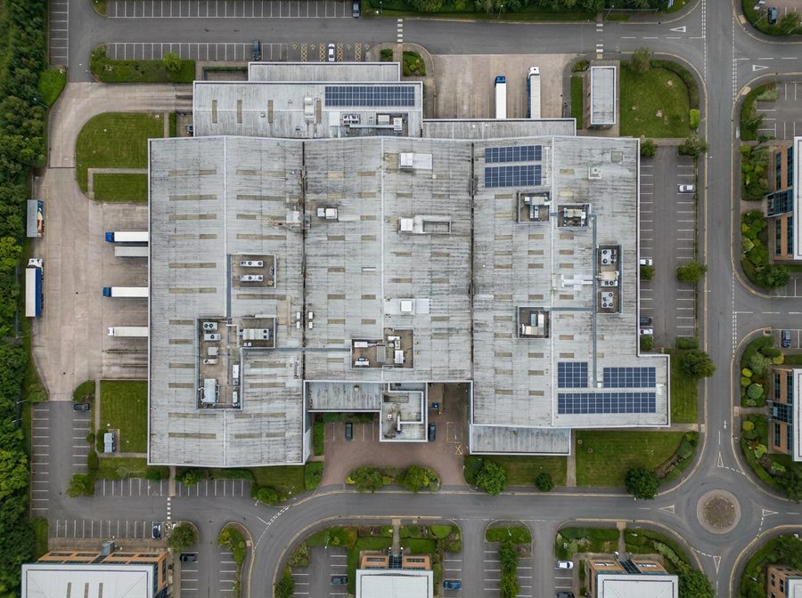 Aerial drone view of a large commercial building roof on a business park
