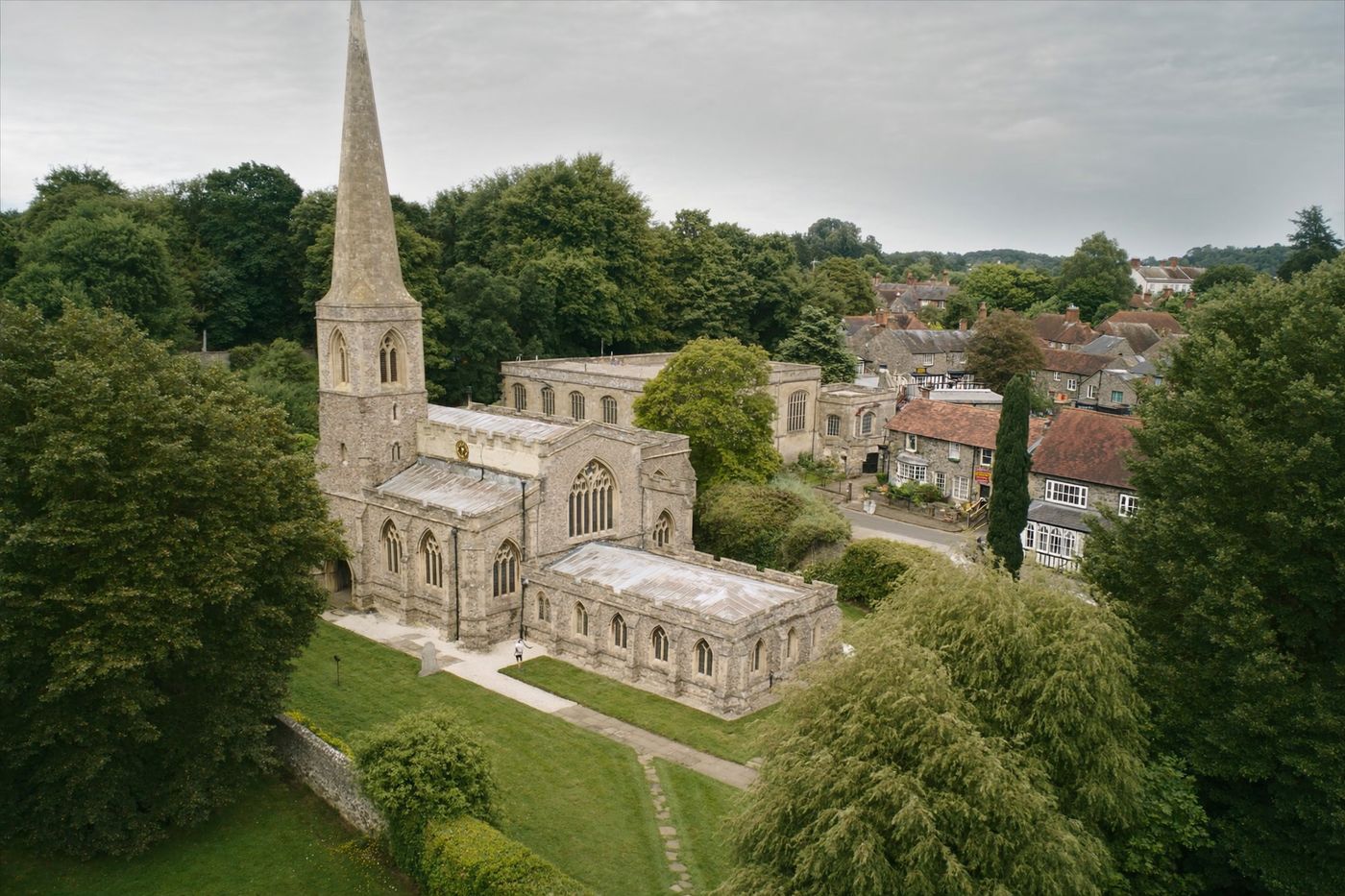 Aerial drone view of a historic listed stone church with spire